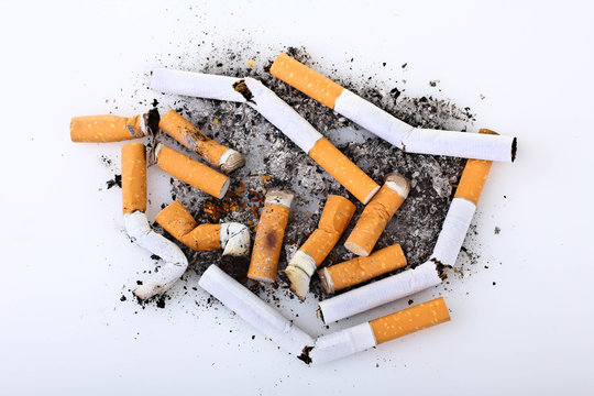 a large number of cigarettes with orange filter extinguished on a white isolated background