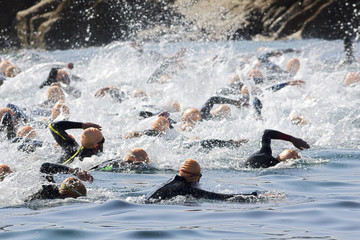 triathlon participants in swim portion of race , selective focus