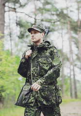 Fototapeta premium young soldier or hunter with gun in forest