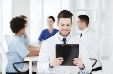 Obraz na płótnie Canvas happy doctor with tablet pc over team at clinic