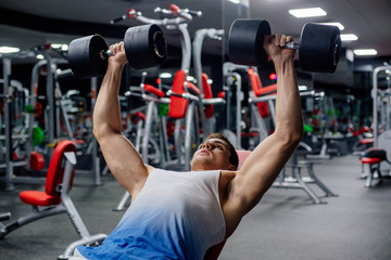 Fototapeta na wymiar young muscular sporty man doing exercises in gym 