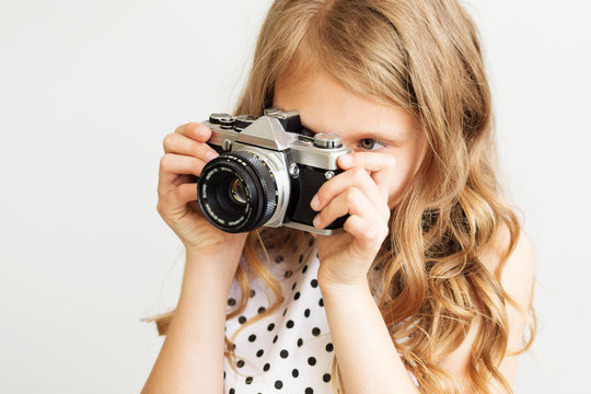 Portrait of a lovely little girl with old SLR film camera