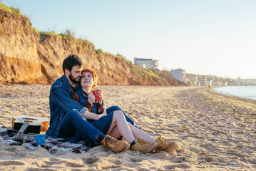 happy loving couple on beach, young man and woman enjoying sunset or sunrise on beach