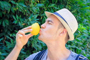 Young Handsome Man kisses a Yellow Lemon, Italy