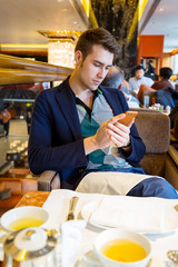 Young Man at English AfternoonTea Ceremony with Beautiful Breakfast Snacks and Desserts