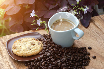 Coffee and cookie on a wood background.