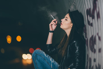 Young girl sitting on the floor and smoke