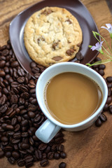 Coffee and cookie on a wood background.