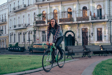 Fototapeta premium young brunette man riding fixed-gear bicycle in the city on a sunny day