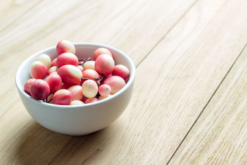 carunda fruit in white dish on wooden background