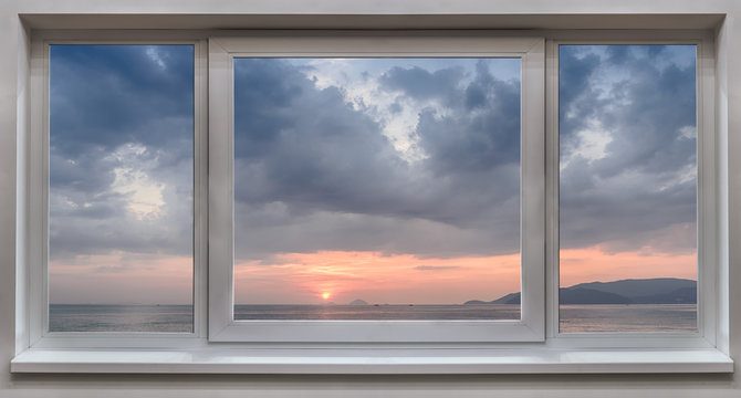A window with the panoramic views of the sea and the beautiful sunrise