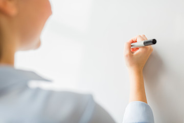 close up of woman writing something on white board