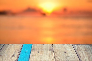 Fototapeta premium Blur tropical sunset beach with old empty wood table background.
