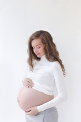 pregnant woman caressing her belly over white 