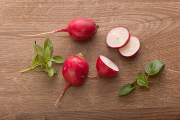 Whole and sliced red radish with fresh green basil