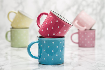 Colorful Ceramic Mugs with White Dots on White Marble Background