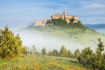 sun light on the old castle and fog in the forest in Slovakia 