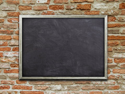 Close-up of one blank blackboard poster frame on orange brick wall background