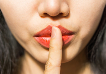 closeup picture of woman making a hush gesture