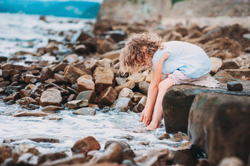 happy child girl playing on the beach on summer vacations