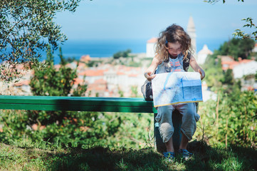 tourist child girl with map traveling on summer vacations in Piran, Slovenia