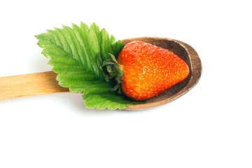 Strawberry with leaf on wooden spoon