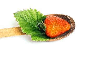 Strawberry with leaf on wooden spoon