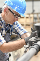 Metalworker in workshop using machine