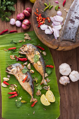 fried mackerel with asian heab on the banana leaf. Cooking  in Asian kitchen. Spicy meal.