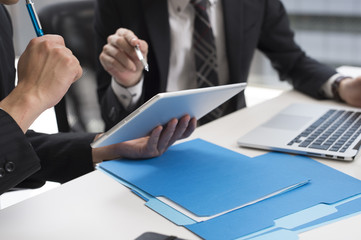 Two businessmen looking at the electronic tablet in office