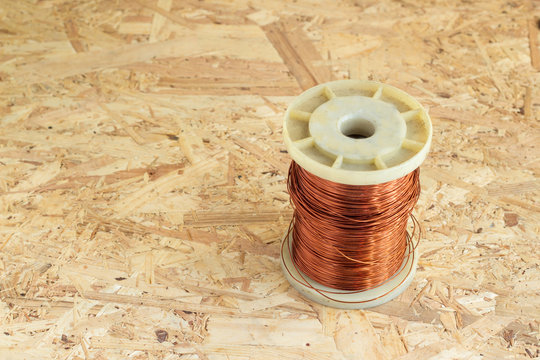 old copper wire rolled on chipboard background