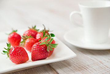 Ripe strawberry fruits on a white plate