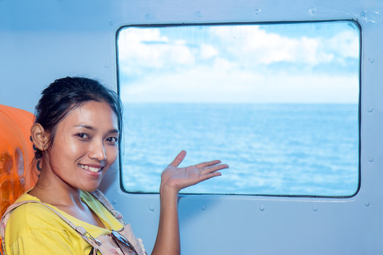 woman pointing at sea from the window of the ship