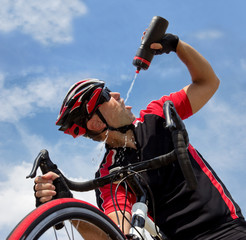 Naklejka premium cyclist drinking from a bottle while riding a bike