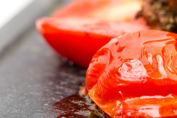 Fresh grilled tomato on metal pan.