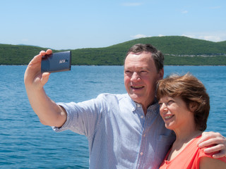 Senior couple taking a selfie by the sea
