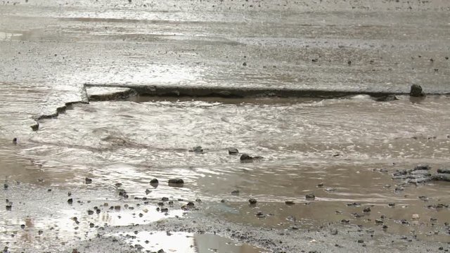 Cars in the city go around big holes. The condition of roads in Russian cities.