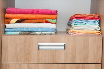 Colorful towels on shelf of the closet