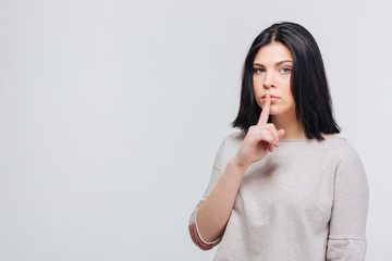 Woman holding finger over lips