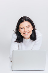 Cheerful brunette girl using laptop