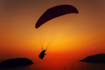 Paraglider silhouette against the background of the sunset sky