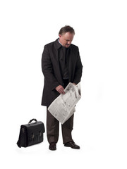 mature businessman with newspaper and bad looking down.