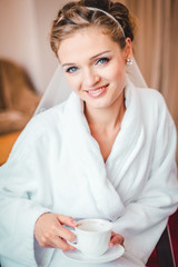 Bride sitting in a chair drinking coffee