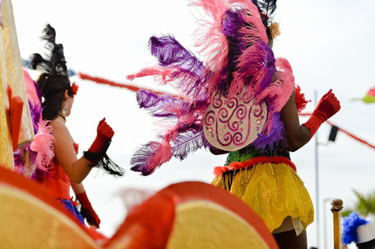 Back view photo of carnaval queen at carnival parade with colorful feathers. 