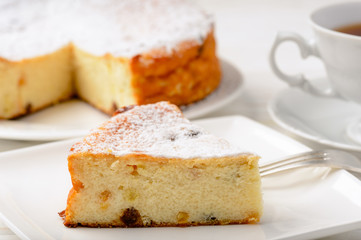 Cheesecake slice on white wooden background.