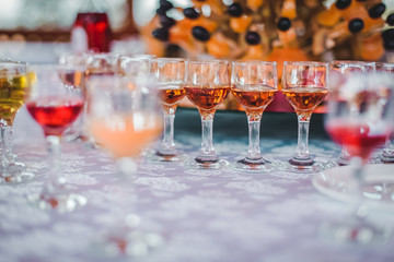 glasses of whiskey at the food covered wooden table. Shallow depth of field