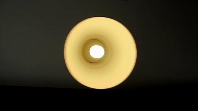The lamp is swinging on a black background.