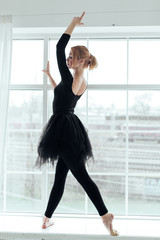 Fototapeta premium ballerina in black tutu over white window