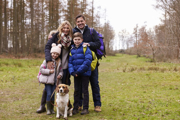 Naklejka na ściany i meble Family and dog in the countryside, full length portrait
