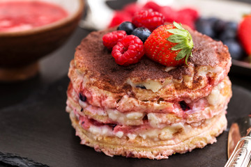 homemade tiamisu with custard cream and berry fruits over slate